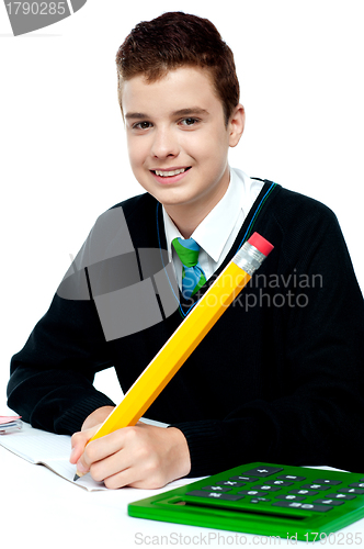 Image of Boy doing homework with calculator beside him