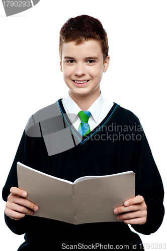 Image of Charming schoolboy holding workbook