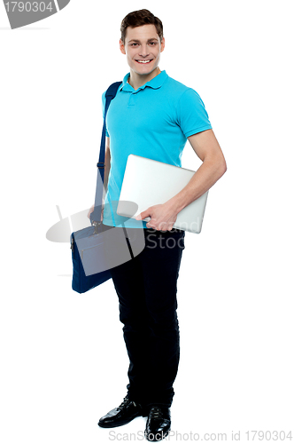 Image of Cheerful man carrying laptop, off to work