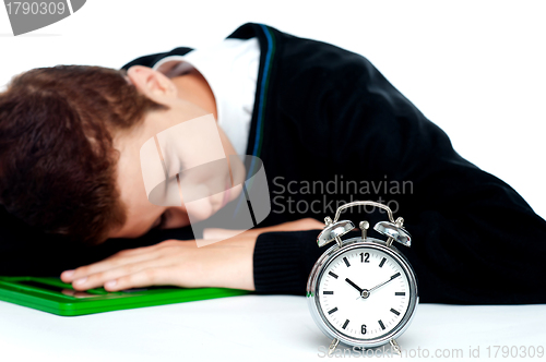 Image of Tired schoolboy sleeping on calculator