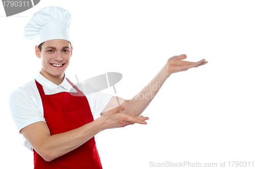 Image of Male chef in red uniform presenting copy space