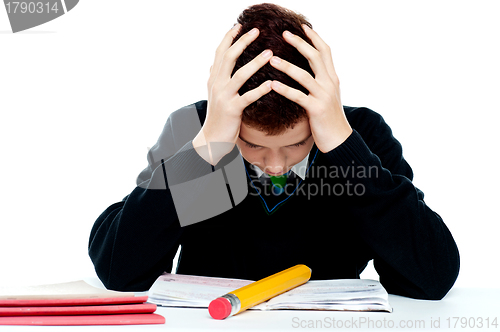 Image of Confused student holding his head in classroom