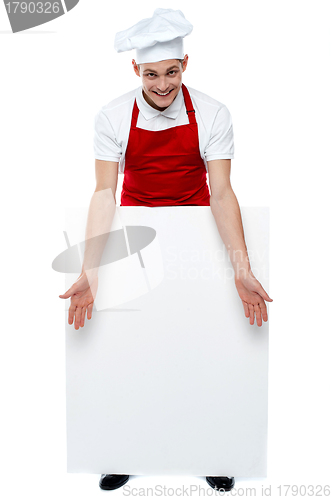 Image of Handsome young cook showing blank billboard