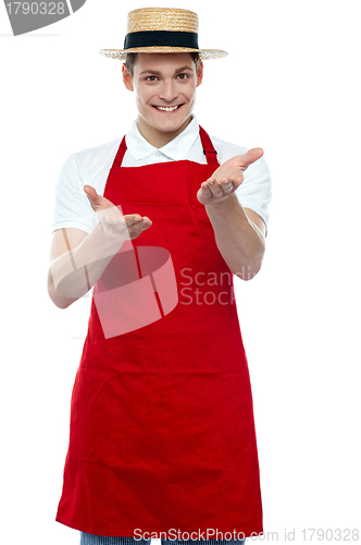 Image of Handsome young male chef welcoming with smile