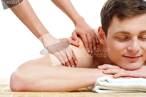 Image of Attractive young man getting spa massage