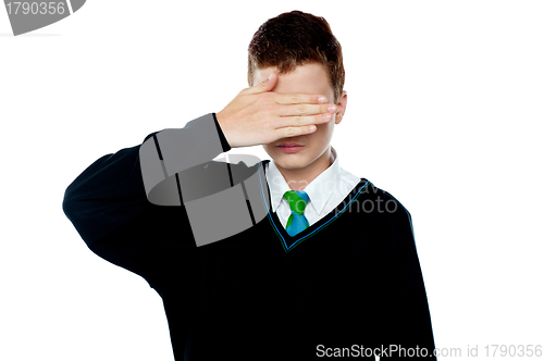 Image of Boy hiding his face and eyes with hand