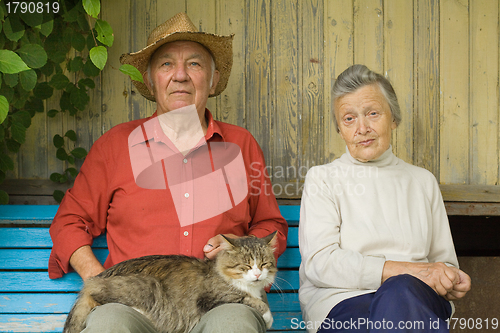 Image of Older couple with cat sit outdoors