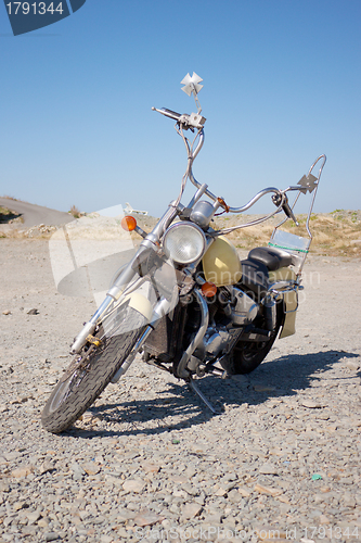 Image of Old motorcycle is in a vacant lot autumn day