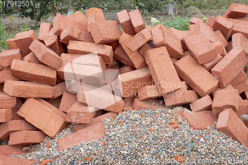 Image of Red clay bricks lying on the gravel