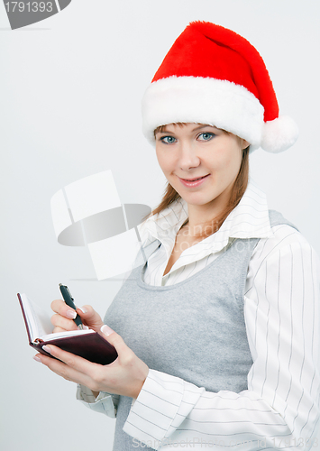 Image of woman with a notebook in a Christmas hat