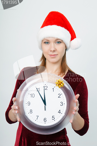 Image of young attractive girl with a clock