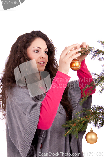 Image of beautiful brunette woman is decorating a christmas tree 