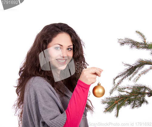 Image of beautiful brunette woman is decorating a christmas tree 