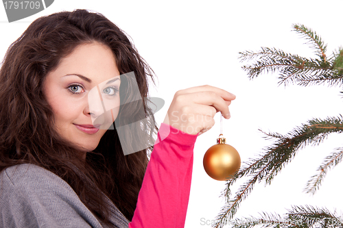 Image of beautiful brunette woman is decorating a christmas tree 