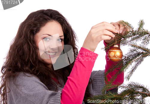 Image of beautiful brunette woman is decorating a christmas tree 