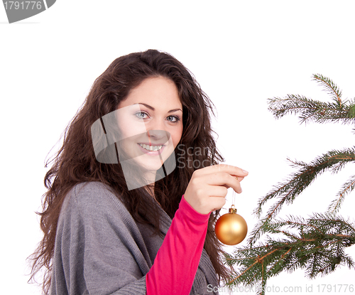 Image of beautiful brunette woman is decorating a christmas tree 