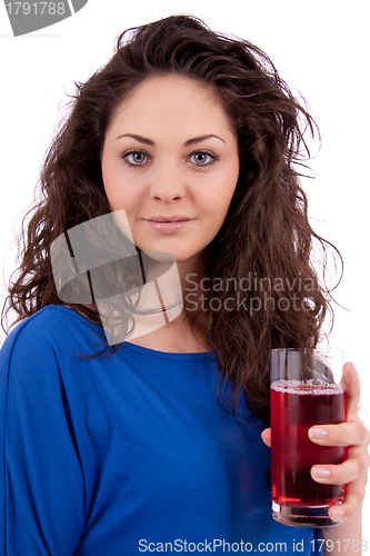 Image of beautiful smiling brunette woman is drinking red juice