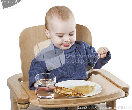Image of young child eating in high chair
