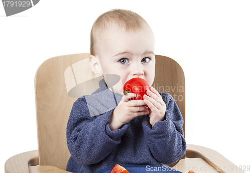 Image of young child eating in high chair