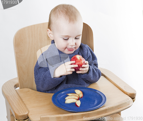 Image of young child eating peaches in high chair