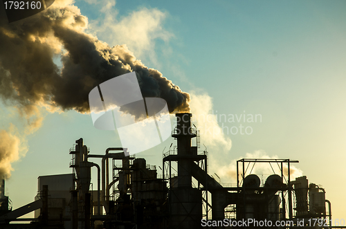 Image of Smoking chimney  at sunset 