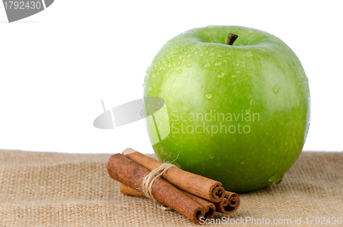 Image of Ripe green apple with cinnamon sticks