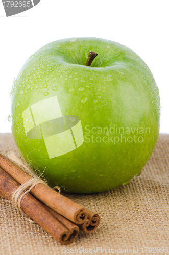 Image of Ripe green apple with cinnamon sticks