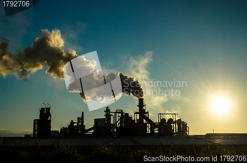 Image of Smoking chimney  at sunset 