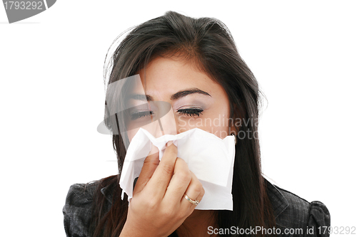 Image of Pretty caucasian businesswoman blowing her nose in the office. 