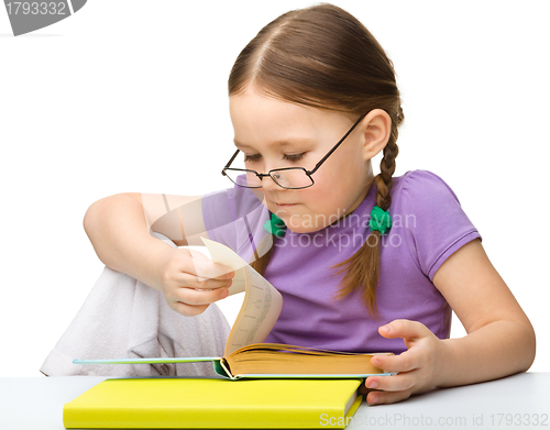 Image of Cute little girl reading book wearing glasses
