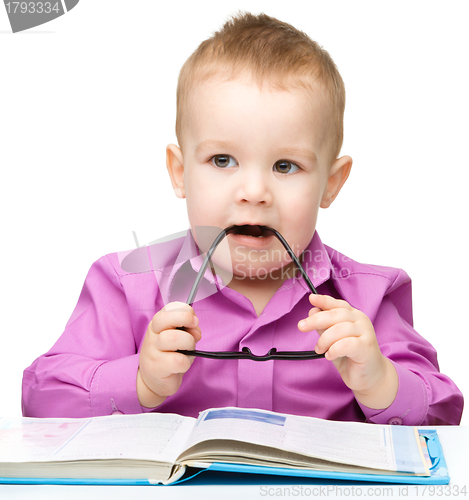 Image of Cute little child play with book