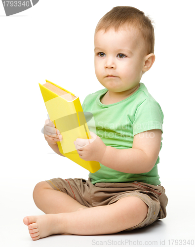 Image of Cute little boy reads a book