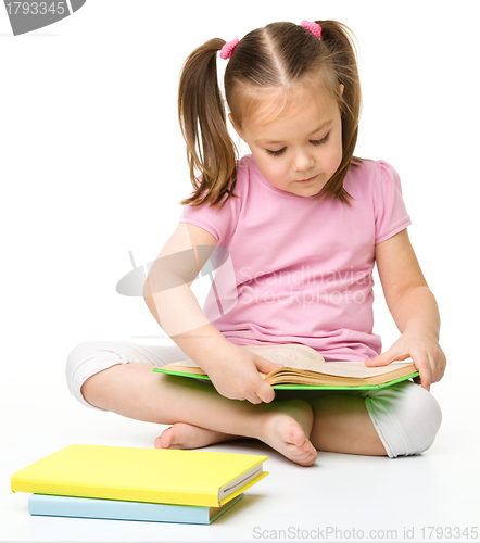 Image of Cute little girl reads a book