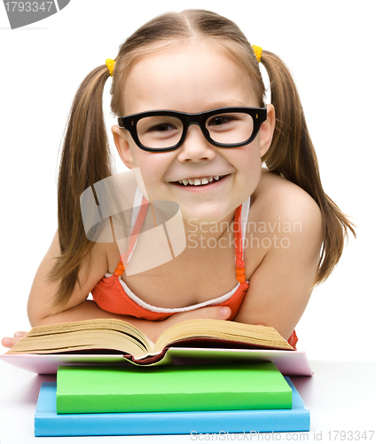 Image of Cute cheerful little girl reading book