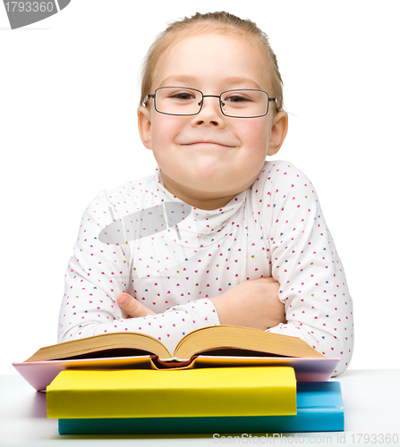 Image of Cute cheerful little girl reading book