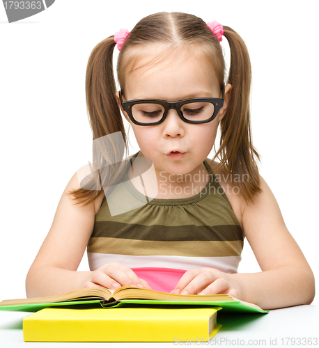 Image of Cute little girl is reading book