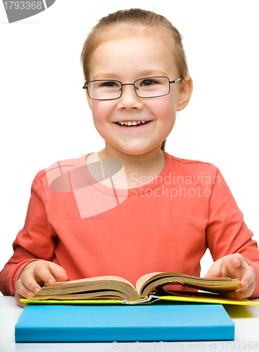 Image of Cute cheerful little girl reading book
