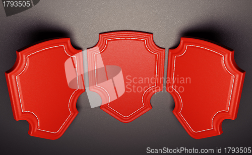 Image of Three red labels or tags over black leather background