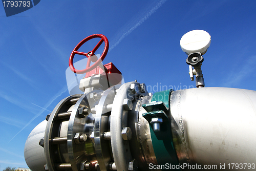 Image of industrial pipelines and valve with a natural blue background