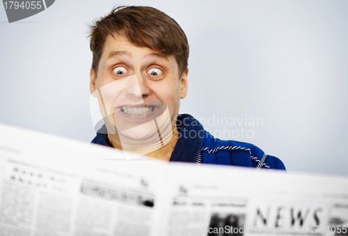 Image of Man shocked by news from the newspaper