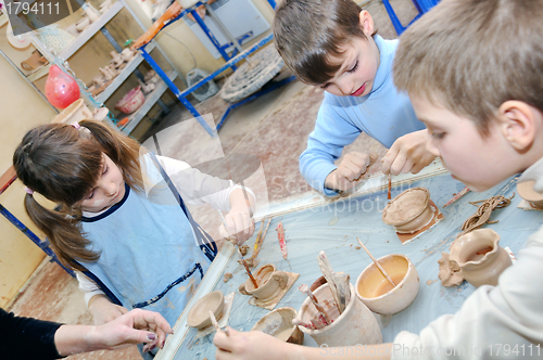 Image of group of children shaping clay in pottery studio