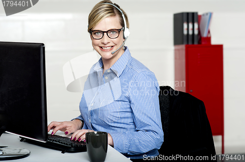 Image of Smiling help desk woman typing on keyboard