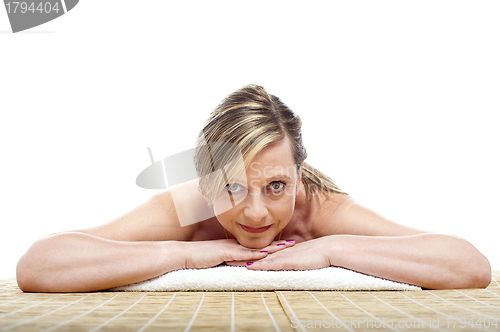 Image of Matured naked woman lying on mattress