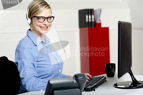 Image of Senior woman sitting in front of computer