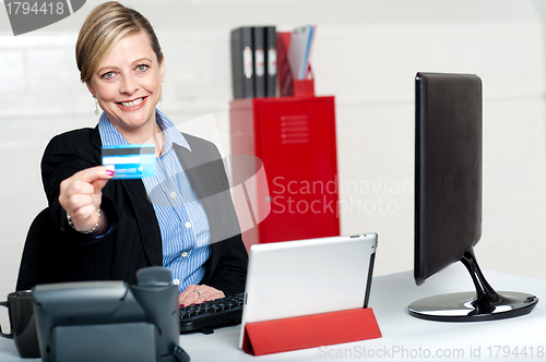 Image of Beautiful corporate woman holding credit card
