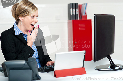 Image of Surprised female secretary looking at lcd screen