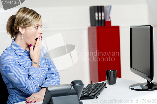 Image of Shocked businesswoman looking at annual reports