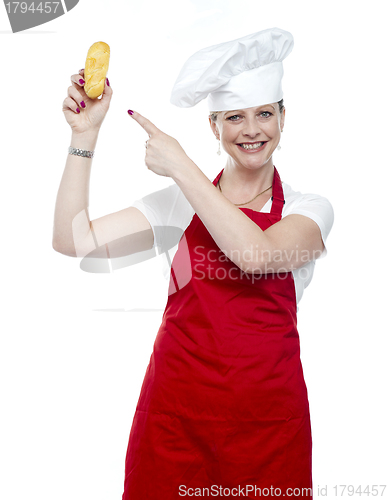 Image of Experienced female cook pointing at bread