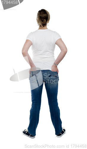 Image of Back view of trendy woman with hands in pocket