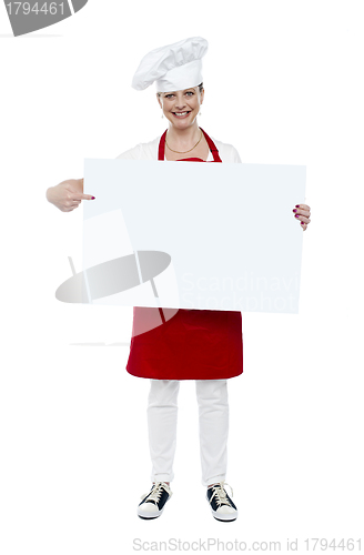 Image of Experienced cook indicating at white banner
